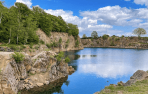 Dalby Stenbrott med klippor, blå sjö och dramatisk natur